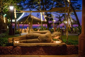 a statue of a woman laying on a rock at night at Beleza By The Beach in Colva