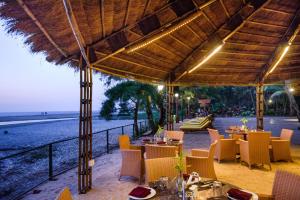 un restaurante en la playa con mesas y sillas en Beleza By The Beach, en Colva