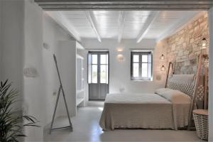 1 dormitorio con cama y pared de piedra en Sand Key Villa 2, en Santa Maria
