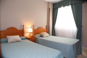 1 dormitorio con 2 camas individuales y ventana en Hotel Restaurante Oviedo, en Luarca