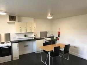 een lege keuken met een tafel en stoelen erin bij Railton House (Paddington) in Londen