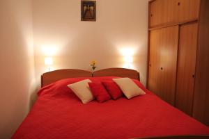 1 dormitorio con 1 cama roja y 3 almohadas en Villa Stella, en Trogir