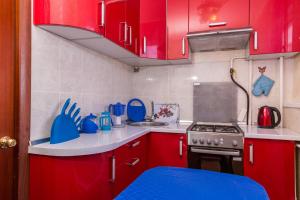 ノヴィ・ウレンゴイにあるFive Stars Comfortの赤いキッチン(赤いキャビネット、コンロ付)