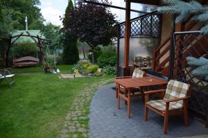 ハイヌフカにあるApartament Promyczekの庭園(木製テーブル、椅子付)
