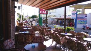 an empty cafe with tables and chairs and a street at Katerini Apartments Hotel in Platanes
