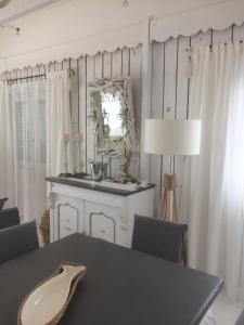 - une salle à manger avec une table et un miroir dans l'établissement Holiday home Chalet Pleine Vue Sur Mer, à Gruissan