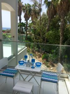 una mesa y sillas en un balcón con vistas al océano en Modern Seaview Beach Studio Limassol, en Limassol
