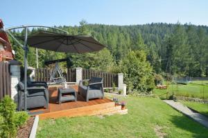 patio z 2 krzesłami i parasolem w obiekcie Gospodarstwo Agroturystyczne Watra w mieście Koninki