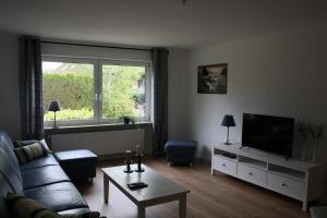 a living room with a couch and a television at Familienfreundliche Ferienwohnung für 4 Personen in Lutzerath