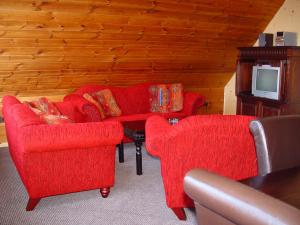 salon z 2 krzesłami i czerwoną kanapą w obiekcie Die Lütte Krabbe w mieście Wremen