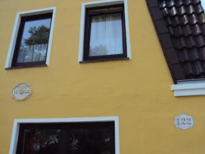 a yellow building with three windows on it at Die Lütte Krabbe in Wremen