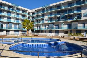 una piscina frente a un gran edificio de apartamentos en Golive Esquirol Beach, en Cambrils