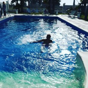 un hombre está nadando en una piscina en Villa Selinus 6598 en Castelvetrano Selinunte