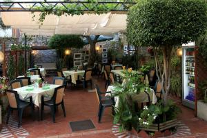a restaurant with tables and chairs and plants at Camere Santa Margherita in Santa Margherita-Sant'Alessio Siculo