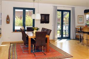 a dining room with a wooden table and chairs at Det gule Hus in Kappeln