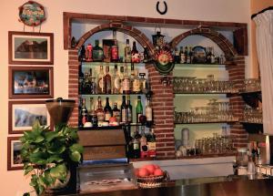 un bar con un montón de botellas en la pared en Camere Santa Margherita, en Santa Margherita-Sant'Alessio Siculo