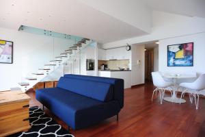 a living room with a blue couch and a staircase at Dolce vita suite in Makarska