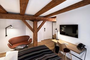a bedroom with a bed and a desk and a television at 71 Nyhavn Hotel in Copenhagen
