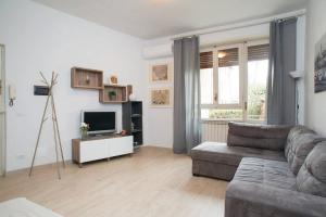 ein Wohnzimmer mit einem Sofa und einem TV in der Unterkunft TwelveHolly apartment in Florenz