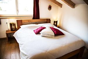 a bedroom with a bed with two pillows on it at B&B Casa sul Lago - Appartamenti in Calceranica al Lago