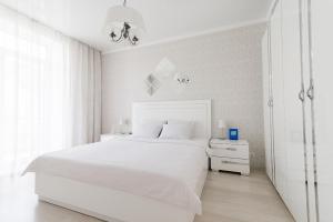 a white bedroom with a white bed and a white cabinet at City Life Apartments on Pushkinskaya in Brest