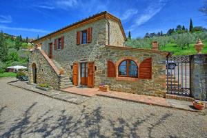 una casa in pietra con cancello e recinzione di Villa Calcinaio by PosarelliVillas a Cortona