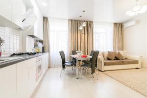 a kitchen and living room with a table and a couch at City Life Apartments on Pushkinskaya in Brest