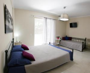 sypialnia z 2 łóżkami i oknem w obiekcie Lalezas Studios w mieście Tolo