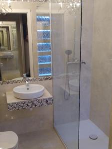 a bathroom with a sink and a glass shower at Manufaktura in Warsaw +6 photos