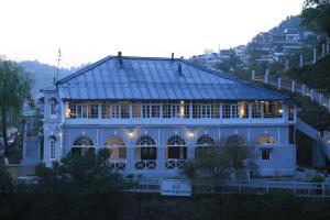 a large white building with a glass roof at Raghu Vilas in Mussoorie