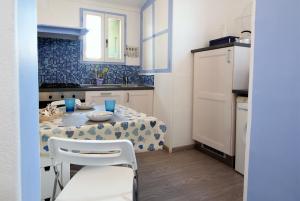 サンレモにあるAppartamento Manolaのキッチン、ダイニングルーム(テーブル、椅子付)