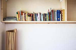 a shelf full of books on a wall at B&B Casa sul Lago - Appartamenti in Calceranica al Lago