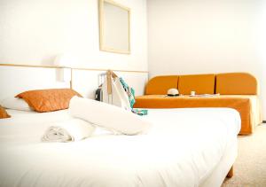 een hotelkamer met 2 bedden en een bank bij Hôtel des Thermes Les Dômes in Vichy