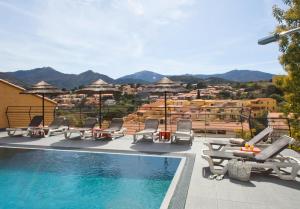 una piscina con sillas y vistas a la ciudad en Le Madeloc Hôtel & Spa en Collioure