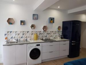 a kitchen with a sink and a washing machine at Appartement de charme citadelle Bastia in Bastia