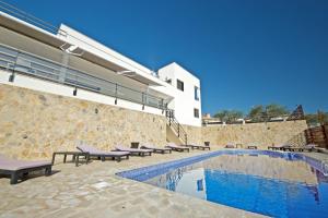una piscina con bancos junto a un edificio en Parabellum, en L'Ampolla