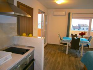 a kitchen and dining room with a table and a kitchen and a room at Studio apartment Luzia in Komiža