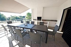 Un comedor con mesa y sillas en un balcón. en Parabellum, en L'Ampolla