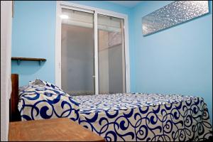 een blauwe kamer met een bed en een raam bij Apartamento Baluarte in Conil de la Frontera