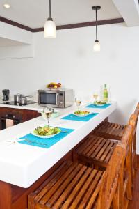 a kitchen with a table with plates of food at Santosha Barbados in Saint Andrew