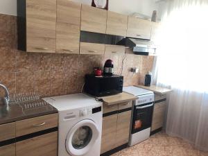 a kitchen with a washing machine and a washer at Apartament Bella in Jurilovca +3 photos