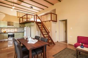 a kitchen and dining room with a wooden table and a staircase at Filio House in Stalos