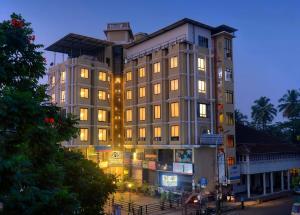 a tall building with lights on in a city at TreeHouse Neptune Inn in Panaji