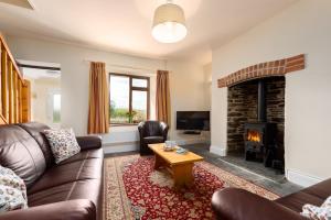 a living room with a couch and a fireplace at Cargurra Park Farm in Boscastle
