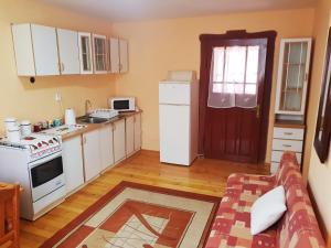 a kitchen with white cabinets and a white refrigerator at Privat DAŇO in Lisková