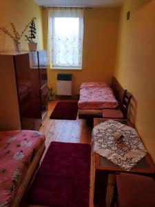 a room with two beds and a table and a window at Privat DAŇO in Lisková