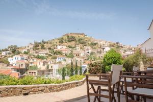 a table and chairs sitting on top of a mountain at Yasemi of Chios "Adults Only" in Volissos