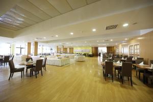 um restaurante com mesas e cadeiras num quarto em Hotel Donat - All Inclusive em Zadar