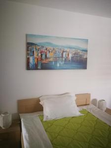 1 dormitorio con 1 cama con una pintura en la pared en Apartments La Dolce Vita en Herceg-Novi