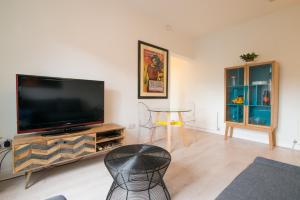 a living room with a large flat screen tv at Burton House Boutique Flat in Manchester